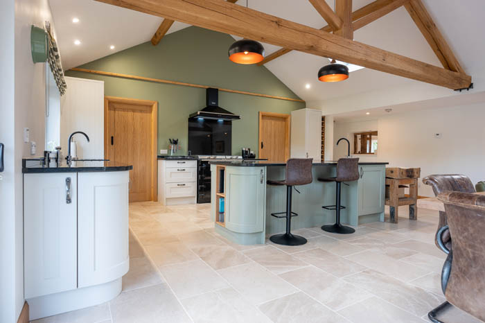 a contemporary style kitchen with no handles and green furniture